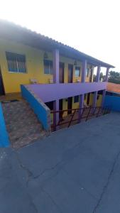 a yellow and purple building with stairs in front of it at Pousada Familiar Beberibe in Beberibe