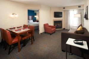 a hotel room with a living room with a couch and a table at Residence Inn by Marriott Saginaw in Saginaw