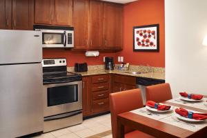a kitchen with a stainless steel refrigerator and a table at Residence Inn by Marriott Saginaw in Saginaw