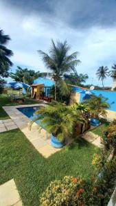 a resort with a swimming pool and palm trees at Pousada Familiar Beberibe in Beberibe