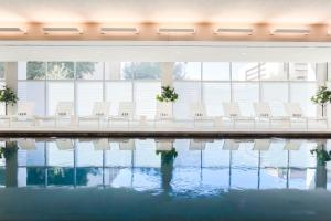 una fila de sillas blancas junto a una piscina en AC Hotel by Marriott Dallas Downtown, en Dallas