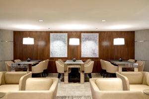 達拉斯的住宿－AC Hotel by Marriott Dallas Downtown，餐厅设有桌椅和木墙