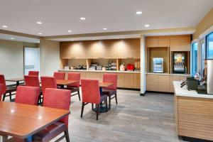 una sala da pranzo con tavoli e sedie e una cucina di TownePlace Suites by Marriott Salt Lake City Draper a Draper