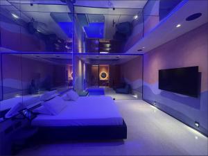 a purple bedroom with a bed and a flat screen tv at Lush Motel Lapa in Sao Paulo