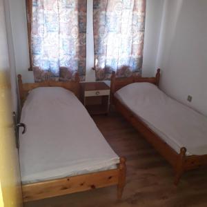 two beds in a small room with two windows at Къмпинг ЕНЕРДЖИ in Varna City