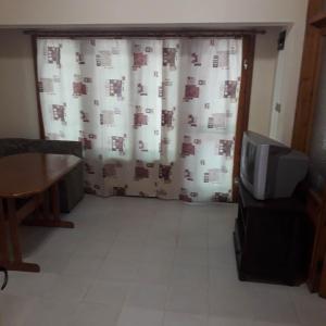 a living room with a curtain and a tv at Къмпинг ЕНЕРДЖИ in Varna City