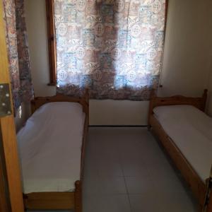 ein kleines Zimmer mit 2 Betten und einem Fenster in der Unterkunft Къмпинг ЕНЕРДЖИ in Warna