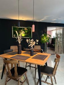 a dining room with a wooden table and chairs at Pink Tropical Champagne in Reims