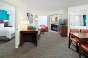 a hotel room with a bed and a desk and a television at Residence Inn Chicago O'Hare in Rosemont
