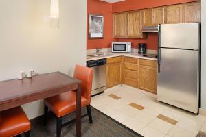 a kitchen with a table and a stainless steel refrigerator at Residence Inn Chicago O'Hare in Rosemont