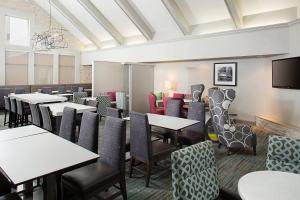 a dining room with tables and chairs and a flat screen tv at Residence Inn Chicago O'Hare in Rosemont