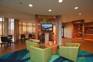 eine Lobby mit Stühlen und einem TV in einem Gebäude in der Unterkunft SpringHill Suites by Marriott Las Vegas North Speedway in Las Vegas