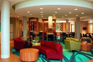 a lobby with a red couch and chairs and tables at SpringHill Suites by Marriott Las Vegas North Speedway in Las Vegas