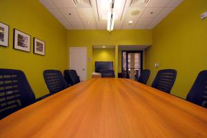 een conferentieruimte met een grote houten tafel en stoelen bij SpringHill Suites by Marriott Las Vegas North Speedway in Las Vegas