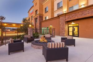 eine Terrasse mit Stühlen und einer Feuerstelle vor einem Gebäude in der Unterkunft Fairfield Inn & Suites Riverside Corona/Norco in Norco