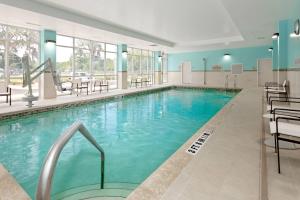 a pool in a hotel with chairs and tables at SpringHill Suites by Marriott Ocala in Ocala