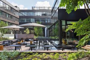 a courtyard with tables and chairs and a building at Courtyard by Marriott Freiburg in Freiburg im Breisgau
