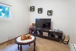 a living room with a table and a tv at Casa el Monte in San Juan del Reparo