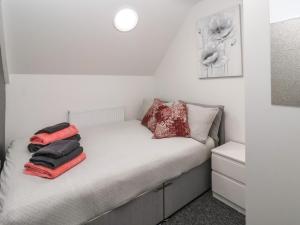 a small bedroom with a bed with red towels on it at The Old Police House in Withernsea