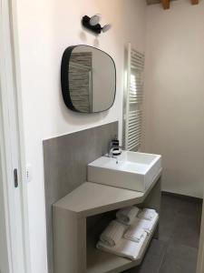 uma casa de banho com lavatório, espelho e toalhas em B&B Il Passo em Urbino