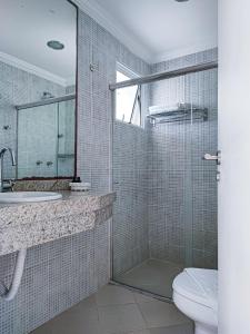 a bathroom with a toilet and a sink and a shower at Hotel Coral Beach in Tamandaré