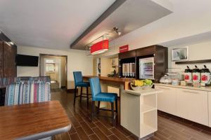 una cocina con encimera y algunas sillas azules en TownePlace Suites Salt Lake City Layton, en Layton