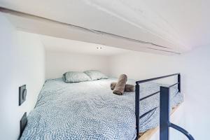 um quarto com uma cama num quarto branco em Lyon Cité-Studio Bellevue Caluire em Caluire-et-Cuire