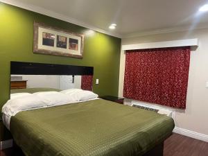 a bedroom with a bed and a red window at Harris Motel in Oakland