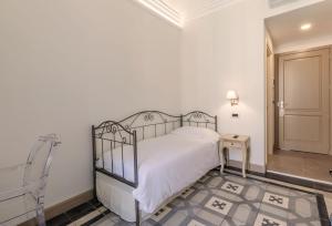 a bedroom with a bed and a chair and a door at XX SETTEMBRE Urban Relais in Turin