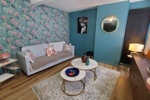 阿拉斯La P'tite Arrageoise的客厅里有一张沙发和一张桌子。