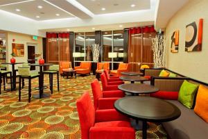 a hotel lobby with red chairs and tables at Courtyard by Marriott St. George in St. George