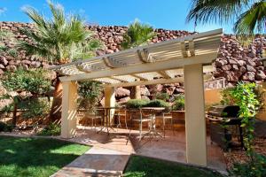 a pergola with chairs and a table in a yard at Courtyard by Marriott St. George in St. George