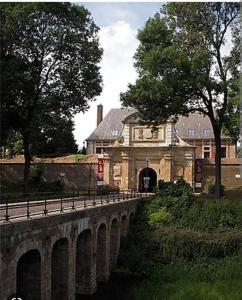 een gebouw met een brug over een rivier met een gebouw bij La P'tite Arrageoise in Arras