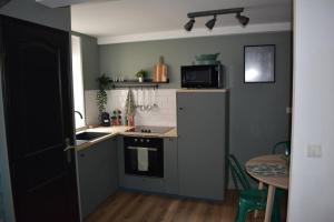 a small kitchen with a sink and a stove at La P'tite Arrageoise in Arras