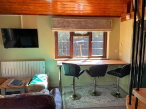 een woonkamer met een bar met krukken onder een raam bij The Annexe at Gomo in East Winch