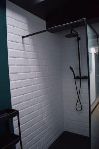 una ducha en una habitación con una pared de ladrillo blanco en La P'tite Arrageoise, en Arras