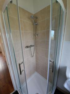 a shower with a glass shower stall in a bathroom at Newmarket in Stornoway