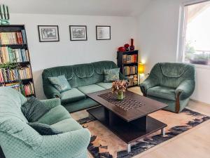 a living room with two green couches and a coffee table at My Parents Guest House in Petrovec