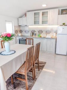 uma cozinha com uma mesa com um vaso de flores em My Parents Guest House em Petrovec