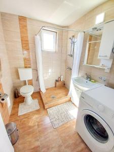 uma casa de banho com uma máquina de lavar roupa e um WC em My Parents Guest House em Petrovec