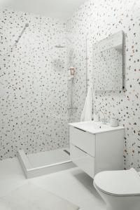 La salle de bains blanche est pourvue de toilettes et d'un lavabo. dans l'établissement Smiling Apartment, à Cluj-Napoca