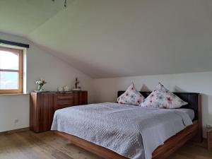Un dormitorio con una cama con almohadas rosas y una ventana en Ferienwohnung Alpenpanorama, en Halblech