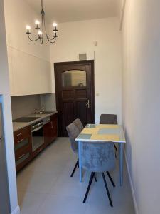 uma cozinha com uma mesa, 2 cadeiras e um lavatório em Apt * Stella em Breslávia
