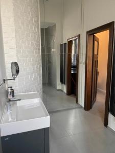a white bathroom with a sink and a glass door at Apt * Stella in Wrocław