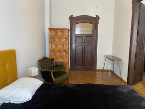 a bedroom with a bed and a chair and a door at Apt * Stella in Wrocław