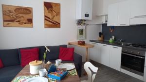 eine Küche mit einem Sofa und einem Tisch in einem Zimmer in der Unterkunft Delizioso bilocale a Trento in Trient