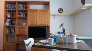 eine Küche mit einem Schreibtisch, einem TV und einem Tisch mit Stühlen in der Unterkunft Delizioso bilocale a Trento in Trient