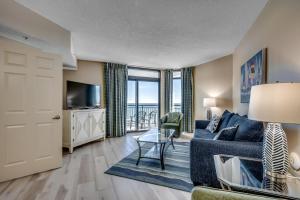 a living room with a couch and a tv at Oceanfront 3BR Caribbean Resort Condo unit 2009 in Myrtle Beach