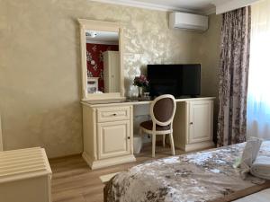 a bedroom with a desk with a tv and a mirror at Vila Royal Mangalia in Mangalia