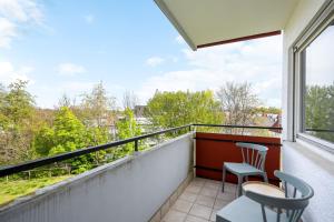 einen Balkon mit 2 Stühlen und einem Fenster in der Unterkunft Sali Homes - FeWo Blühendes Barock Ludwigsburg in Ludwigsburg